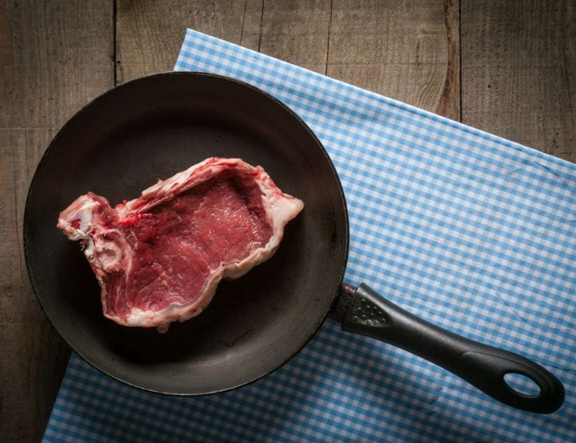 surowy kawałek mięsa na patelni