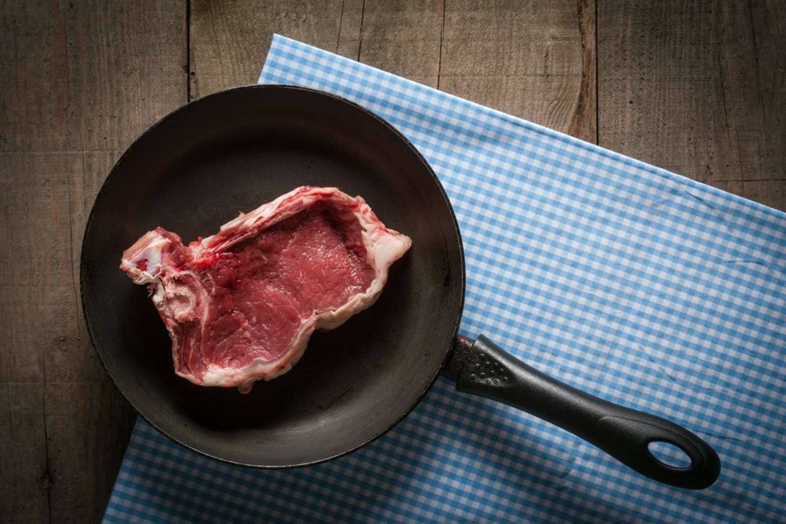 surowy kawałek mięsa na patelni
